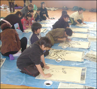 이와키마찌 체육관에서 연을 만들고자 그림을 그리고  있는 어린이들 